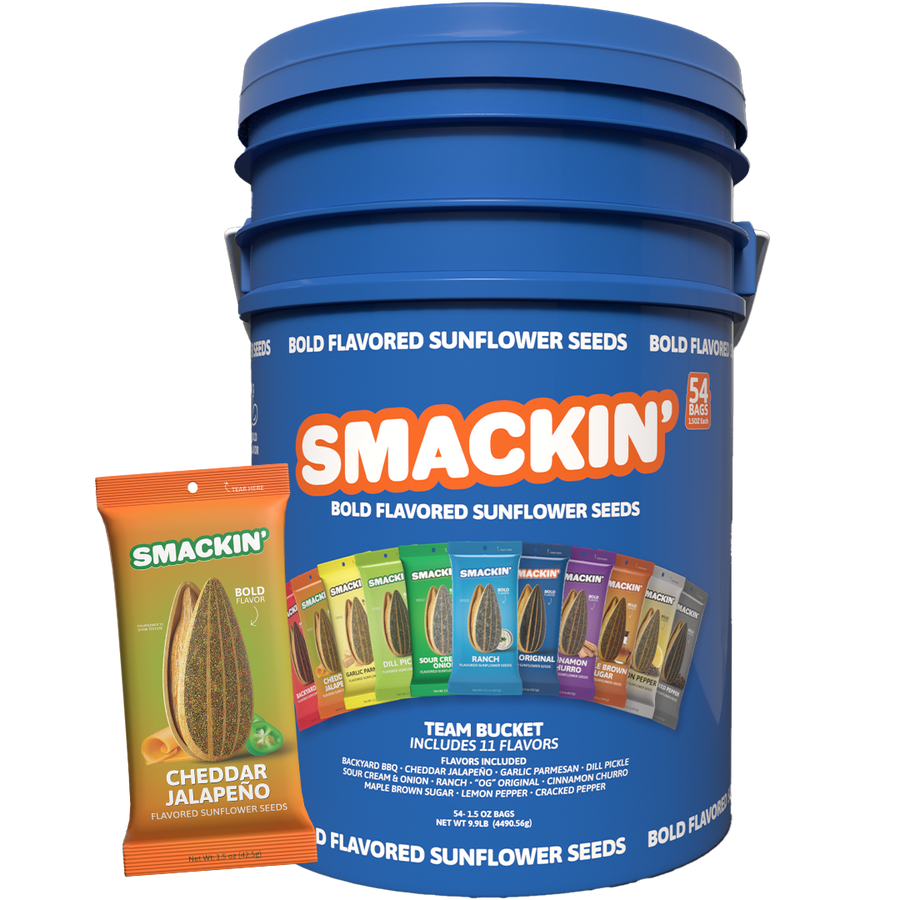 Smackin' Bold Flavored Sunflower Seeds Team Bucket, a large blue container holding 54 bags with 11 distinct flavors like Cheddar Jalapeño and Dill Pickle, shown next to an individual orange bag of Cheddar Jalapeño seeds
