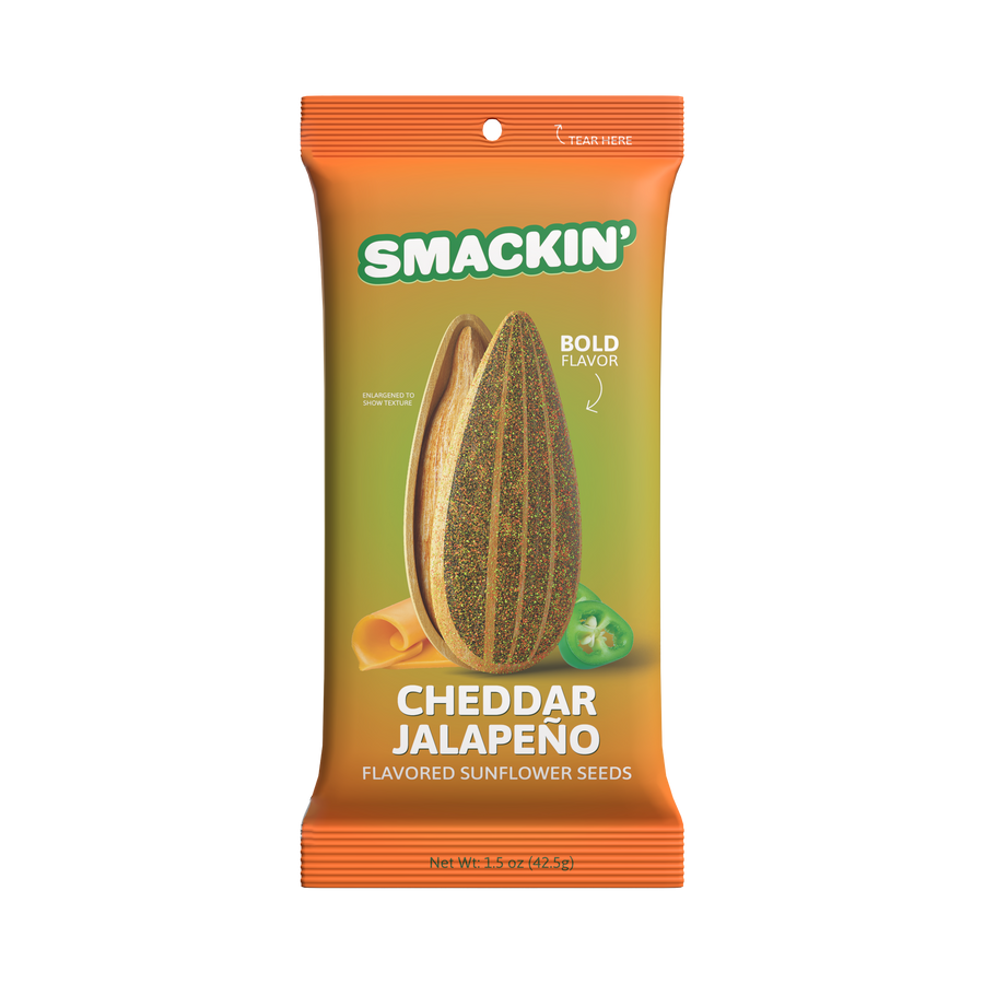 Commercial product packaging for Smackin' Cheddar Jalapeño flavored sunflower seeds featuring an orange and green gradient design with an enlarged seasoned sunflower seed, a slice of rolled cheddar cheese, and a fresh green jalapeño slice alongside "Bold Flavor" text