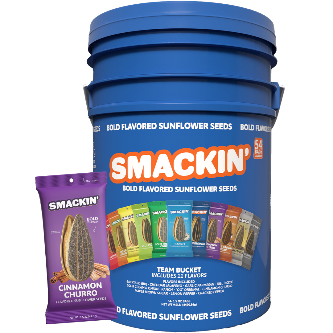 Smackin' Bold Flavored Sunflower Seeds Team Bucket a large blue container with an orange logo and listing 54 bags from 11 distinct flavors, presented with a purple individual Cinnamon Churro flavored seed bag