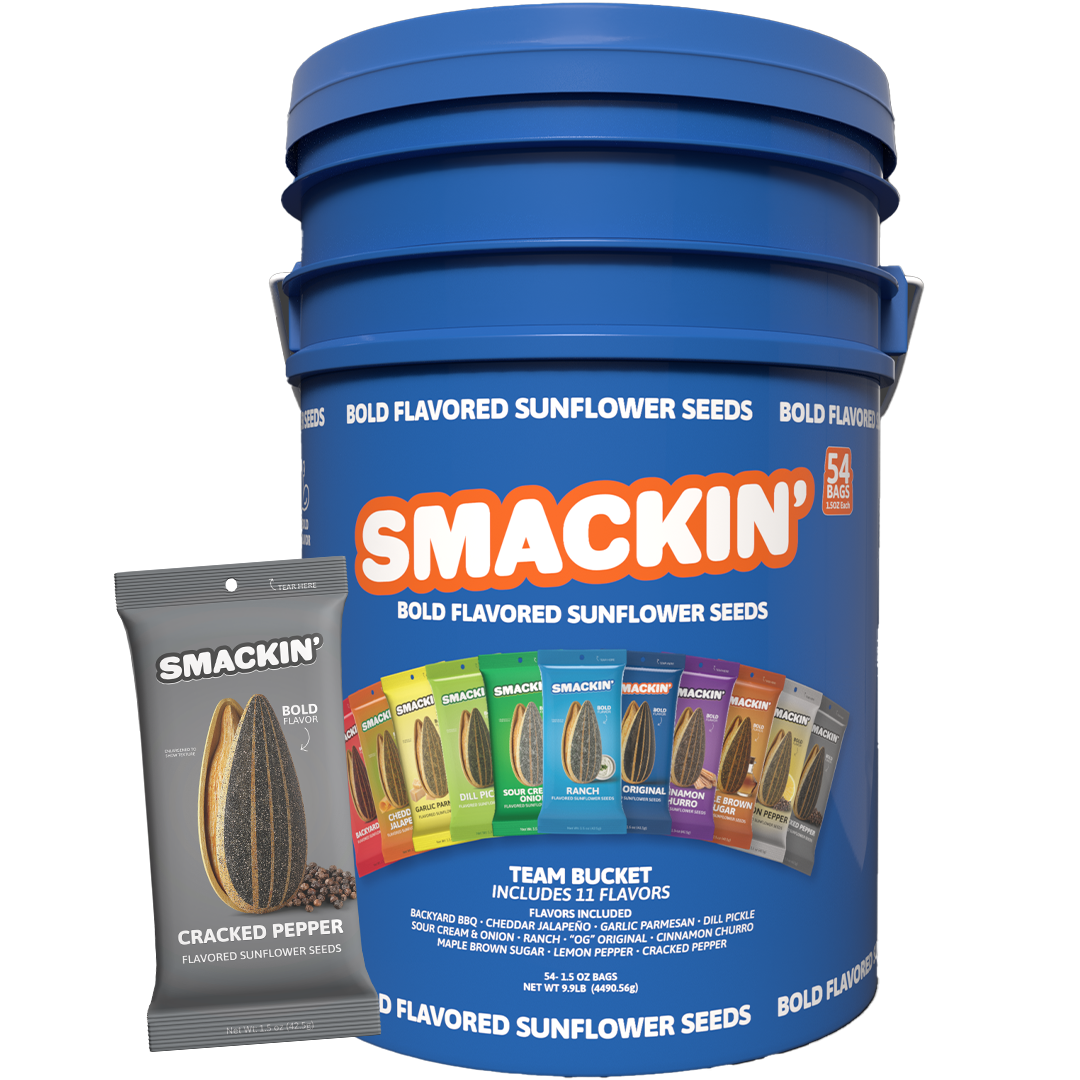 A large blue Smackin' Team Bucket of 54 bold flavored sunflower seed bags prominently featuring a gray Cracked Pepper bag and a colorful array of 11 different flavor packs