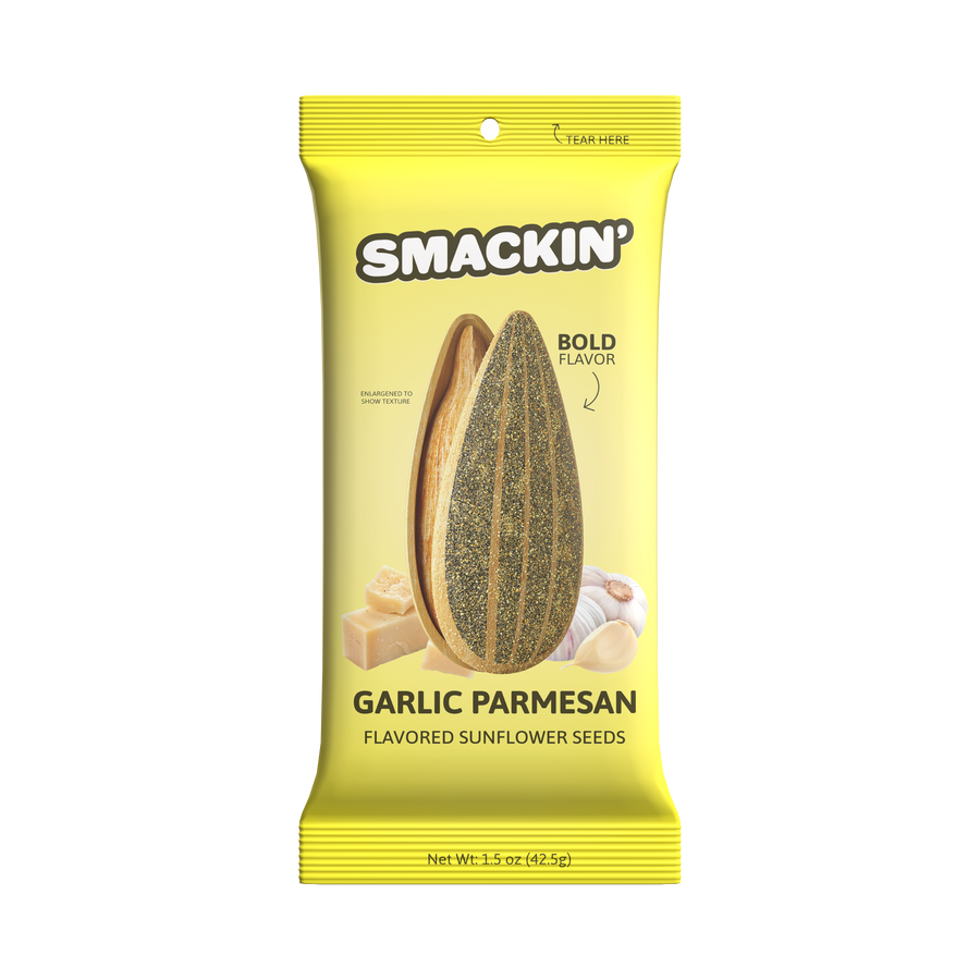Product Photography: A bright yellow Smackin' Garlic Parmesan flavored sunflower seeds package displays an enlarged textured sunflower seed, blocks of parmesan cheese, and garlic cloves with a "BOLD FLAVOR" label