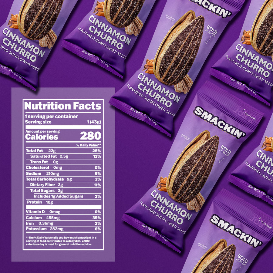 Product photography of multiple purple Smackin' Cinnamon Churro Flavored Sunflower Seeds packages featuring glittering seed illustrations and cinnamon sticks, diagonally arranged on a vibrant purple background with a prominent Nutrition Facts label to the left