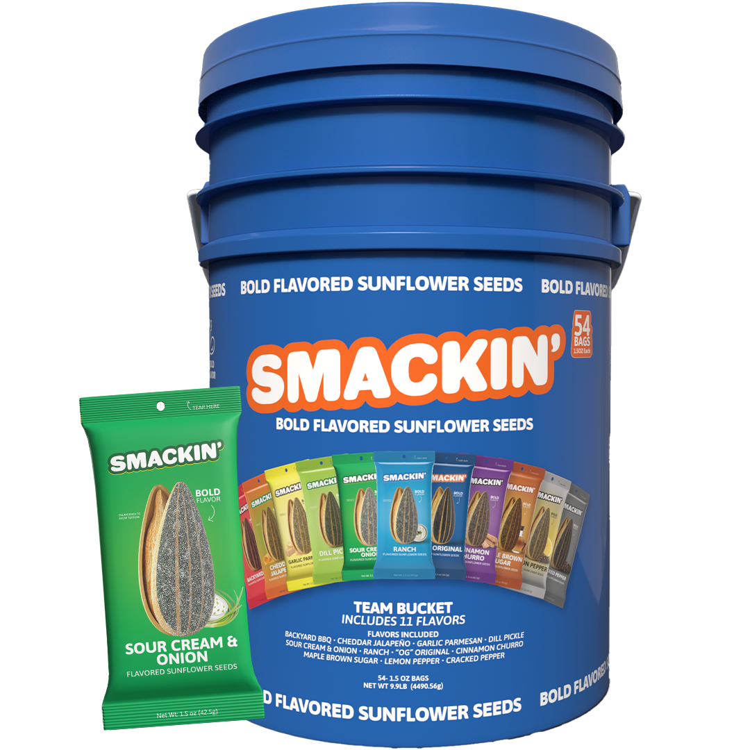 Digital product photo of a large blue Smackin' Bold Flavored Sunflower Seeds team bucket containing 54 bags, featuring a front label showing a vibrant row of flavor bags including Sour Cream & Onion and Ranch, with a prominent green Sour Cream & Onion bag in the foreground