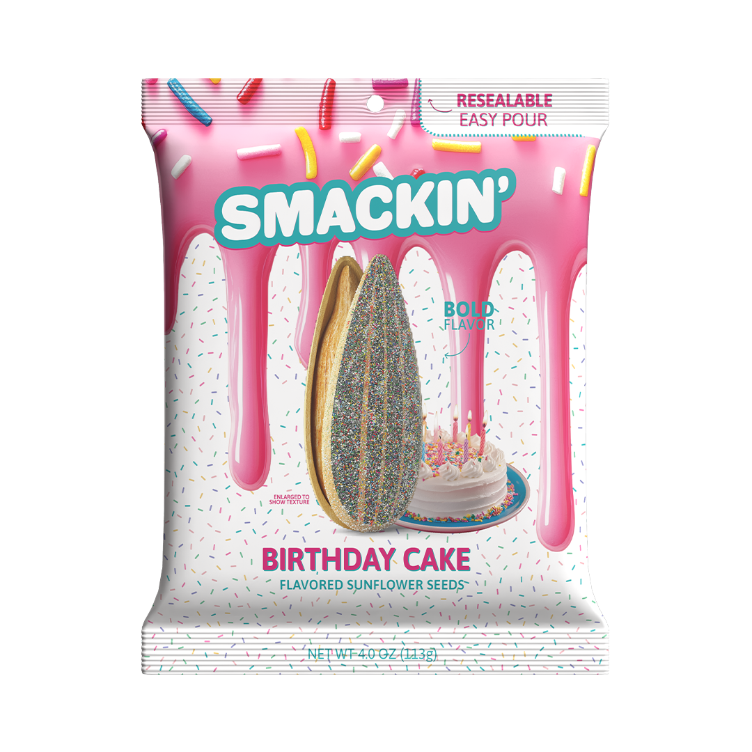 Product photography, unidentified artist, Smackin' Birthday Cake Flavored Sunflower Seeds bag on a white background displaying a pink frosting drip design, scattered colorful sprinkles, an enlarged glitter-coated sunflower seed, and a miniature birthday cake with lit candles