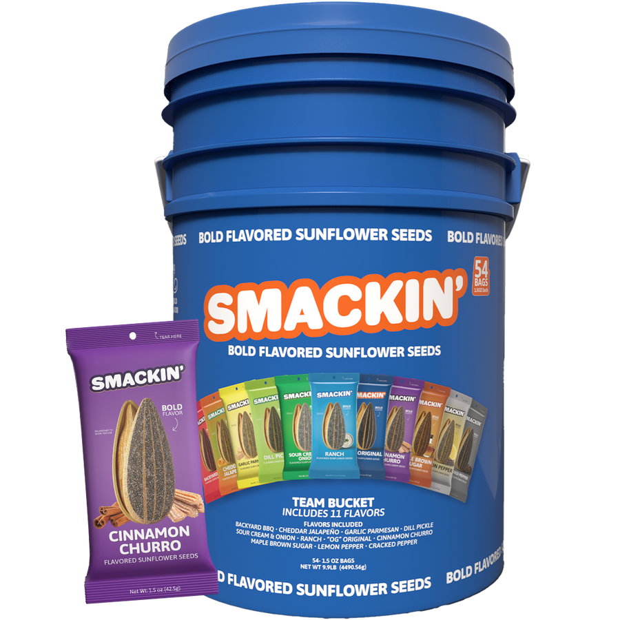 Smackin' Bold Flavored Sunflower Seeds Team Bucket a large blue container with an orange logo and listing 54 bags from 11 distinct flavors, presented with a purple individual Cinnamon Churro flavored seed bag